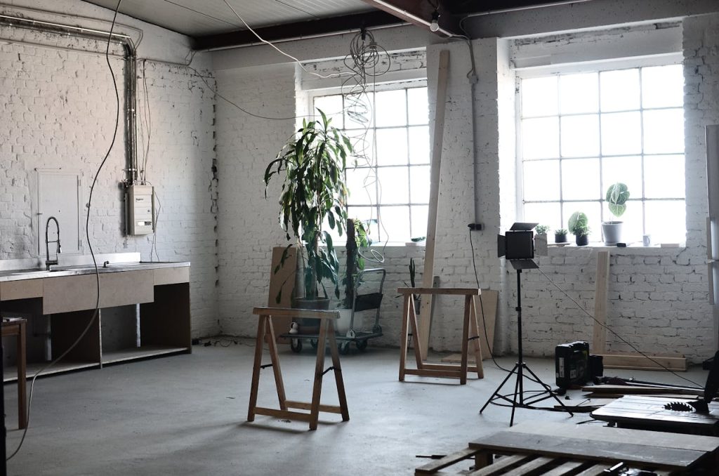 Mastering the First Impression: Your intriguing post title goes here Spacious industrial loft under renovation with scattered tools and natural light from large windows.